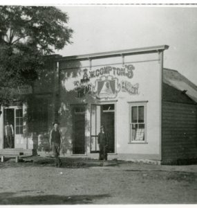 Black and white photo showing Compton's early photography studio - a small building with a facade that sticks up.