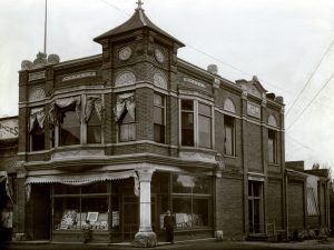 Black and white image of Compton's Photography Studio, a two-story brick building with windows across the storefront.