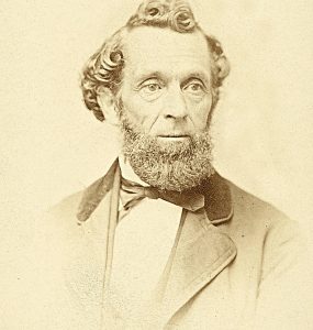 Sepia photo of Lorenzo Snow - man with curly hair and beard in a suit.